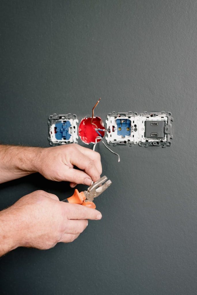 an-electrician-using-pliers-to-repair-the-ac-power-plugs-and-sockets-5691590 Crop faceless electrician using pliers for installation sockets and switches in new apartment