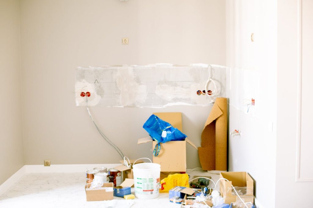 room-renovation-3615721 A room undergoing renovation with tools, supplies, wiring, and paint cans scattered around.
